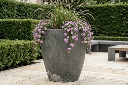 Grand pot de fleur extérieur de 100 cm en béton anthracite mat sur terrasse contemporaine avec graminées et verbena